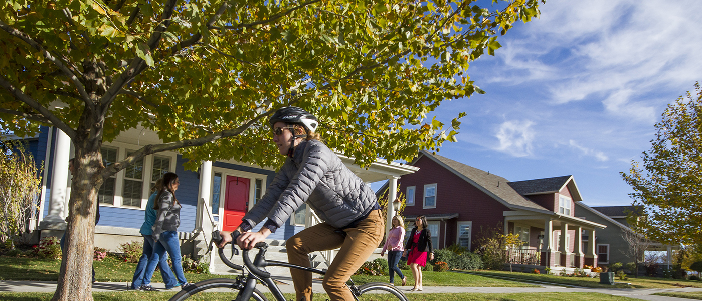 Bicyclist in the foreground and pedestrians in the background in Daybreak.