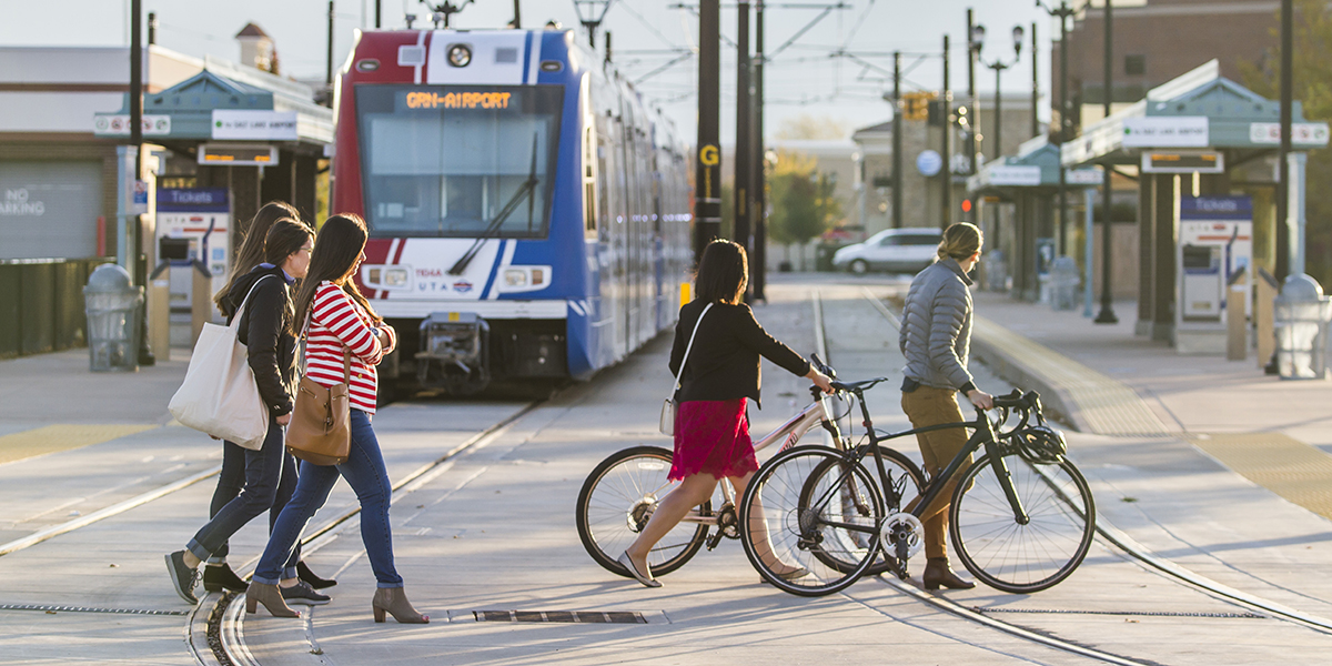 Pedestrians and bicyclists cross the TRAX rails in West Valley City.